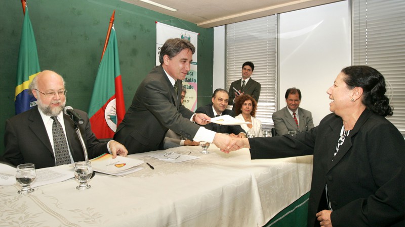 Governador Germano Rigotto durante cerimônia de instalação da Divisão da Direitos Humanos da Defensoria Pública. Na foto: Governador Germano Rigotto entrega para Sra. Teresinha de Jesus Kersche, matricula onde conta como atual proprietária do imóvel em qu
