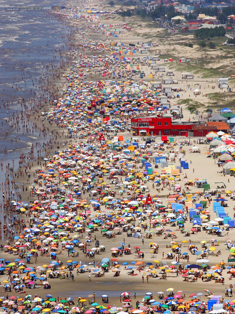 Um grande número de veranistas lotou a beira da praia em Capão da Canoa neste domingo (18), no Litoral Norte do Estado.