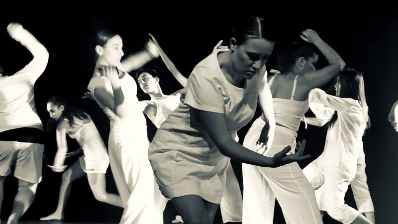 Imagem em preto e branco com diversos estudantes dan&ccedil;ando ao centro