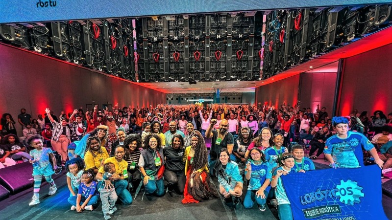 Imagem dos empreendedores selecionados para representar o RS na edição nacional do Expo Favela 2023. Ele estão juntos celebrando a escolha. Há várias pessoas no fundo da foto com as mãos levantadas.