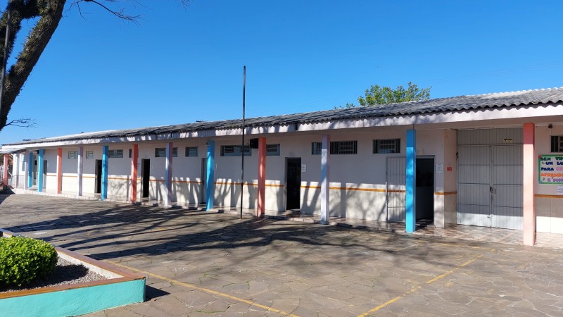 Foto externa mostrando o pátio interno e as portas abertas das salas de aula da Escola General Amaro Bittencourt, em Bento Gonçalves.