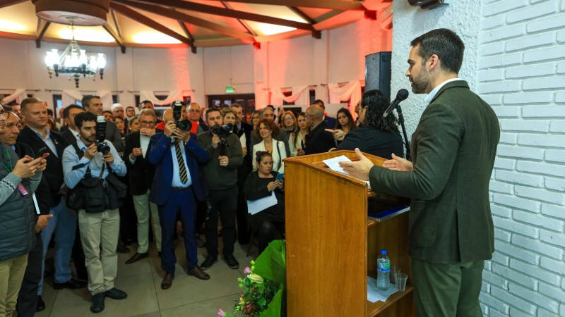 Governador Eduardo Leite, em pé, diante de um púlpito de madeira, fala ao microfone para um grande grupo de pessoas que lotam o salão nobre do Parque Ildefonso Simões Lopes, em Pelotas, na abertura da 97ª Expofeira.