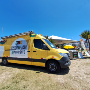 Imagem da Secretaria de Esporte e Lazer, do programa Esporte e Lazer em Movimento, estacionada em uma praia do litoral gaúcho.