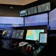 Imagem de uma sala de operação com diversas telas e comandos.