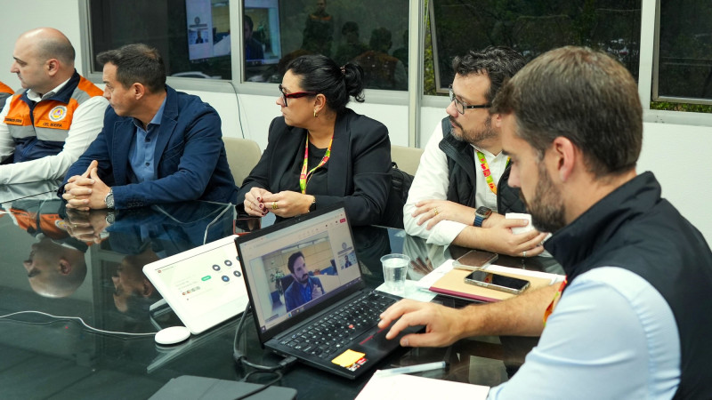 Leite em reunião com Anatel. De perfil diante de um notebook conversando com o representante da Anatel por videoconferência. Mais quatro pessoas são vistas participando da reunião sentadas à mesa.
