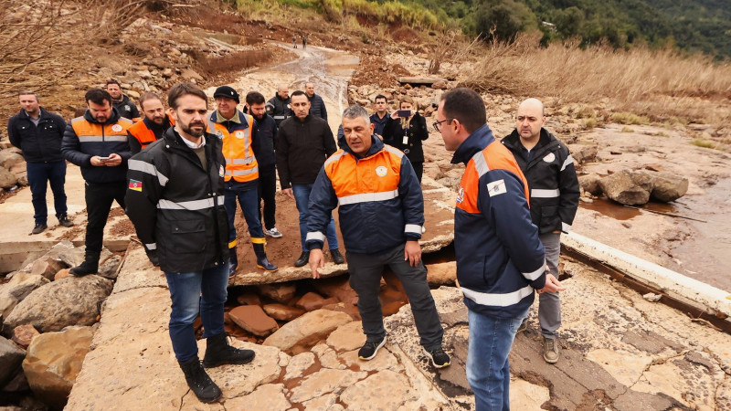 Leite Visita ponte levada pela enchente em Bento Gon&ccedil;alves ap&oacute;s enchentes. Ele est&aacute; em p&eacute; sobre um dos peda&ccedil;os da ponte acompanhado de outras pessoas.