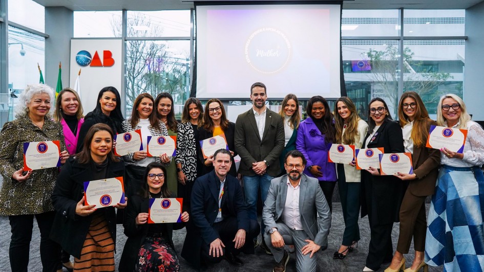 Foto posada com Leite e diversas pessoas em pé e agachadas após a entrega do Selo EmFrente, Mulher 2024