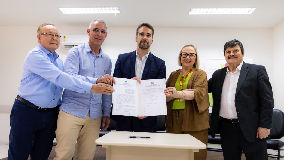 Foto posada com Leite e mais três homens e uma mulher segurando o documento recém-assinado.