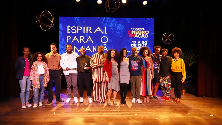 Premiados, curadores e equipe do Festival Cinema Negro em Ação sobre o palco ao final do festival.