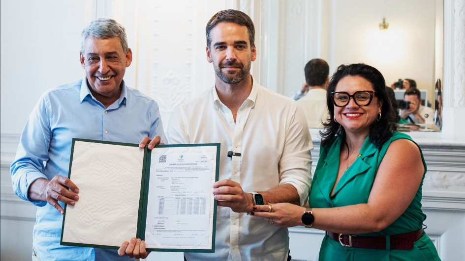 Foto posada de Leite, Melo e Marjorie segurando o documento recém assinado.