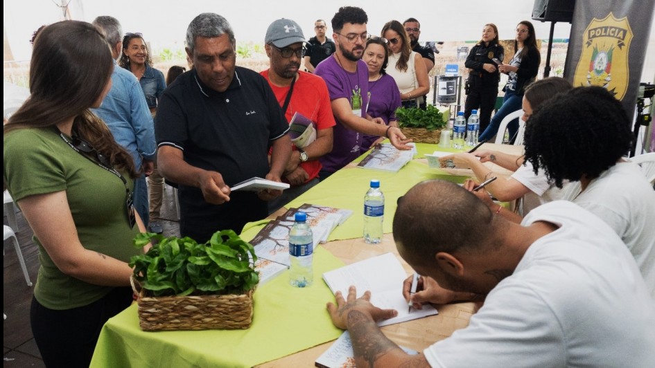 Apenados autografando livro do qual são coautores na Feira do Livro de porto Alegre 2024.