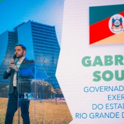 Gabriel atrás de um púlpito transparente falando durante a abertura do Décimo Segundo Cosud.