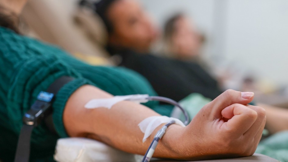 Pessoa com o braço estendido, doando sangue.