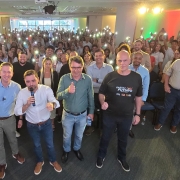 Foto posada dos participantes reunidos e com luzes dos celulares acesas na recepção do Partiu Futuro Reconstrução em Rio Grande.