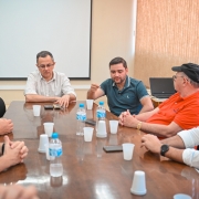 Imagem de uma reunião sobre ponte em Porto Mauá. Oito pessoas aparecem na imagem.