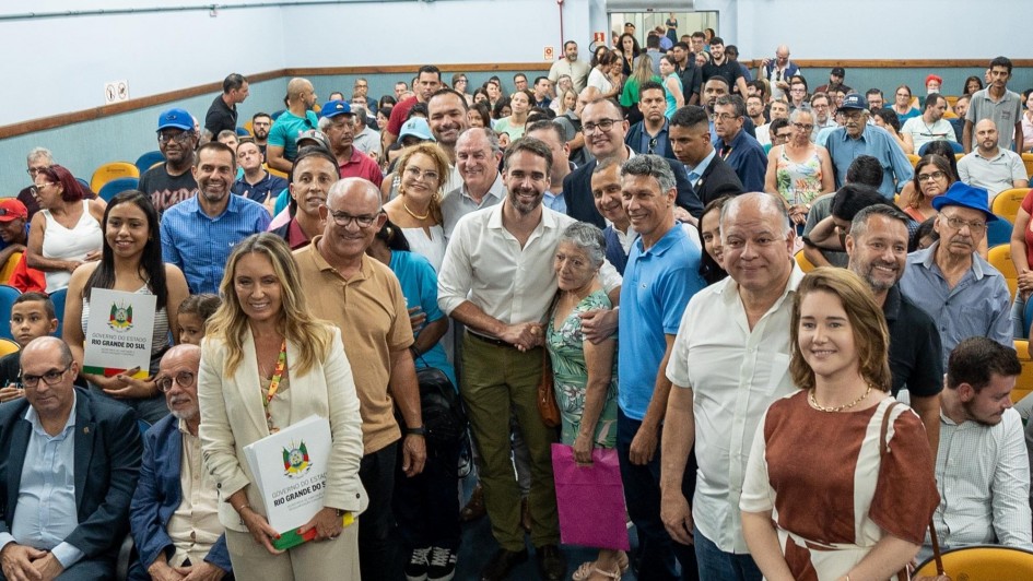 Foto posada com as pessoas presentes à entrega de títulos de regularização fundiária em Gravataí.