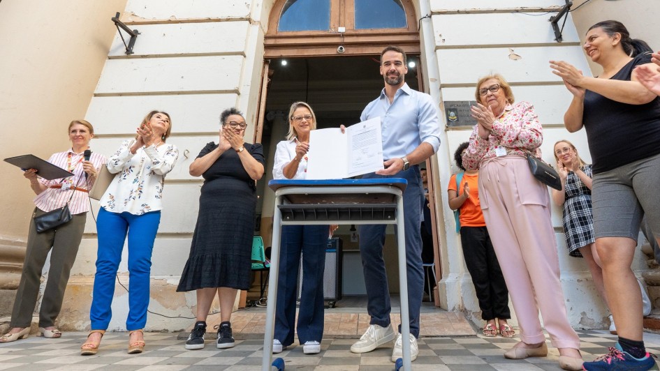 Foto posada de Leite segurando o documento recém assinado junto com a secretária de obras.