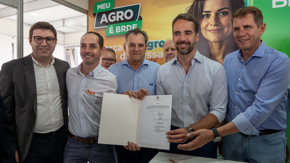 Foto posada de Leite e Polo mais três homens segurando o documento recém-assinado.