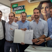 Foto posada de Leite e Polo mais três homens segurando o documento recém-assinado.