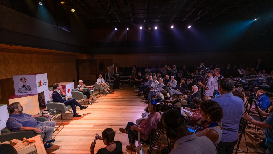 À esquerda quatro pessoas em cadeiras e, à direita, a plateia de jornalistas, na coletiva de imprensa de inauguração do Teatro Simões Lopes Neto.