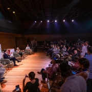 À esquerda quatro pessoas em cadeiras e, à direita, a plateia de jornalistas, na coletiva de imprensa de inauguração do Teatro Simões Lopes Neto.