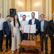 Foto posada das pessoas segurando, juntamente com Leite, o documento recém assinado. 