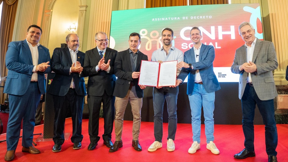 Foto posada de Leite e mais seis pessoas segurando o documento recém assinado no lançamento da CNH Social.