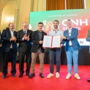 Foto posada de Leite e mais seis pessoas segurando o documento recém assinado no lançamento da CNH Social.