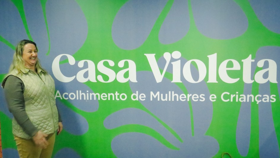 Denize em frente a placa da Casa Violeta   Giovanni Disegna