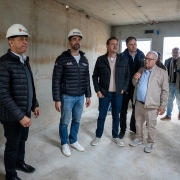 Imagem mostra governador Eduardo Leite ao centro, cercado por outras quatro pessoas, dentro de uma cada em contrução