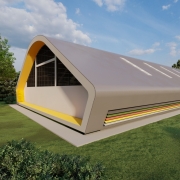  A foto é uma maquete do exterior de um ginásio com um design moderno e telhado curvo. A fachada tem faixas coloridas e um painel amarelo na entrada. A estrutura é construída sobre um gramado com árvores ao redor e um caminho pavimentado.