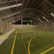 : A foto mostra uma maquete de uma quadra poliesportiva coberta. A quadra tem piso claro com marcações de basquete, e o teto é alto, com estrutura metálica e material translúcido que permite a entrada de luz natural.