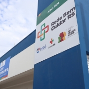 Foto ao ar livre da fachada da unidade. O edifício é azul, com uma grande placa branca em que está escrito Rede Bem Cuidar, com a logo do programa e do governo do Estado.