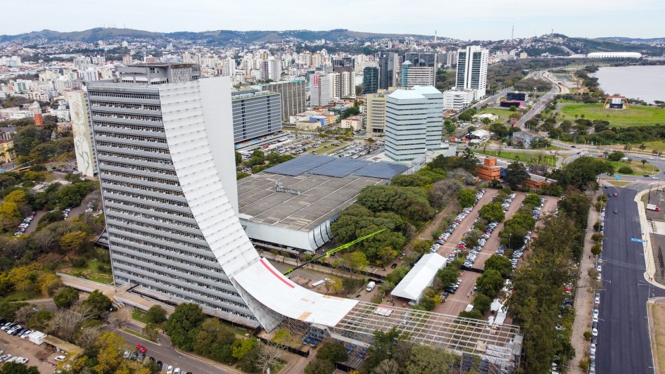 Foto em plano geral do Caff, que aparece à esquerda do quadro, com a rampa sendo construída em sua lateral. A imagem enquadra a cidade de Porto Alegre, com vários edifícios, áreas verdes e estacionamentos.