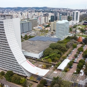 Foto em plano geral do Caff, que aparece à esquerda do quadro, com a rampa sendo construída em sua lateral. A imagem enquadra a cidade de Porto Alegre, com vários edifícios, áreas verdes e estacionamentos. 