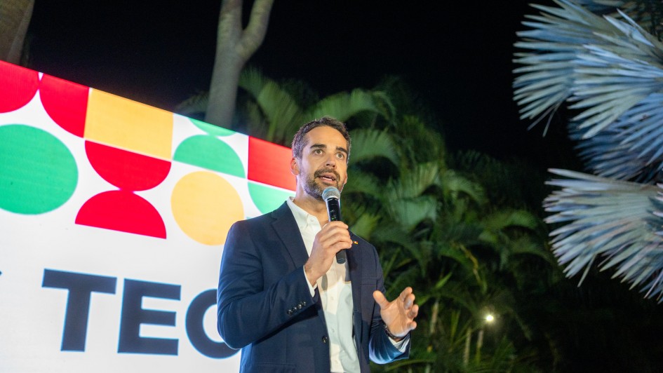 O governador Eduardo Leite está ao centro da imagem, falando ao microfone. Ao fundo, há um painel colorido (nas cores verde, vermelho e amarelo), com a identidade visual do RS Tech.