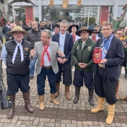 Cena mostra o secretário Ernani Polo segurando uma lamparina com a Chama Crioula, em pé à direita da foto. Ao seu lado esquerdo estão os secretários da Cultura, Eduardo Loureiro, e de Turismo, Ronaldo Santini, e dois tradicionalistas. Todos estão pilchados. 