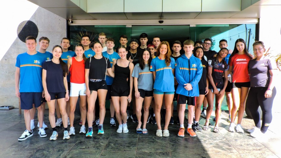 Foto mostra um grupo de atletas, em pé, pousando para foto. 