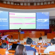 Auditório amplo com cadeiras dispostas em formato semicircular, onde ocorre o THA&CASSPS Innovation Summit, realizado em 15 de setembro de 2025, em Pequim, na China. No centro, uma palestrante apresenta no púlpito, enquanto dois grandes telões exibem informações sobre o evento e o programa Inova RS, com destaque para áreas como saúde, educação, economia criativa, tecnologia e turismo. Participantes acompanham a apresentação sentados, alguns com laptops e materiais de apoio sobre as mesas.