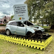 Imagem ao ar livre de um carro acidentado com um balão que remete ao de conversas pelo celular, que diz: A vida é mais urgente do que qualquer mensagem. DetranRS e Governo do Estado do Rio Grande do Sul.