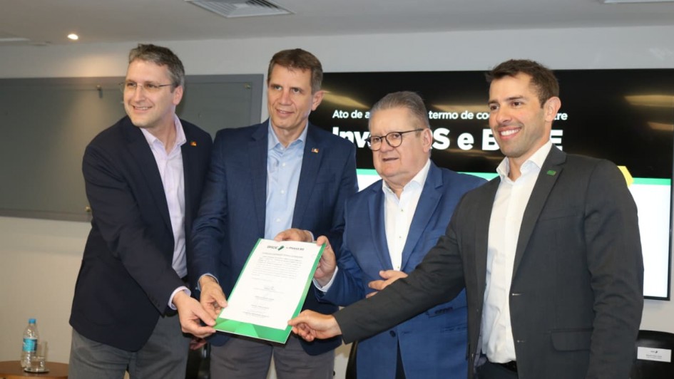 Foto mostra o secretário Ernani Polo, o diretor-presidente do BRDE, Ranolfo Vieiras Júnior, (ambos de terno azul, ao centro), o presidente da Invest RS, Rafael Prikladnicki e o diretor de Planejamento do BRDE, Leonardo Busatto. Eles seguram juntos um documento e posam para foto.