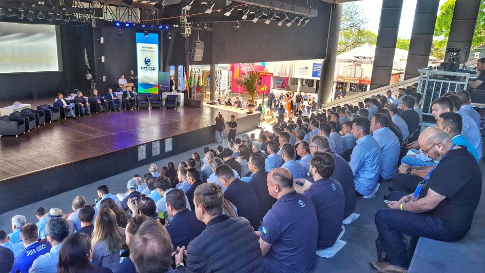 Foto mostra auditório com plateia em primeiro plano voltados para o palco onde estão várias autoridades.