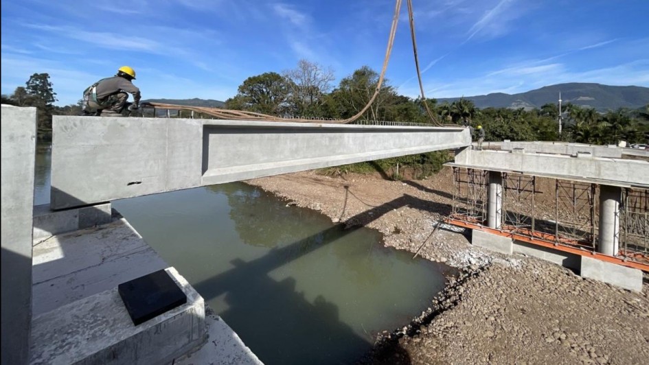 Foto mostra obra em ponte sobre rio.