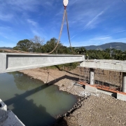 Foto mostra obra em ponte sobre rio. 