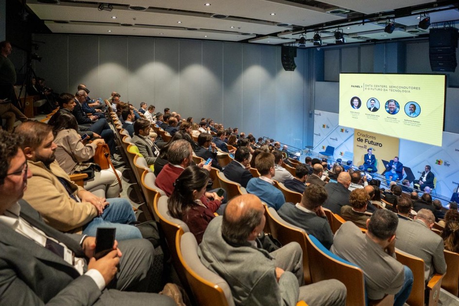 Vista ampla do auditório lotado durante o painel do evento Criadores de Futuro. A plateia acompanha atentamente os palestrantes sentados no palco, sob iluminação moderna e ambiente corporativo.