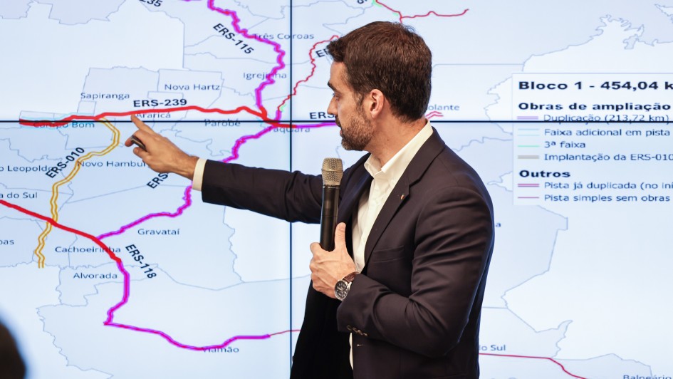 Imagem mostra o governador do Rio Grande do Sul, Eduardo Leite, apontando, sobre mapa projetado em telão, a malha rodoviária envolvida no projeto de concessões do governo estadual.