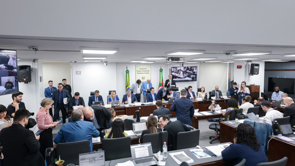 Foto mostra sala de sessões da Comissão de Finanças da Assembleia Legislativa do Estado, com movimentação de pessoas em debate e encaminhamentos durante votação do projeto de lei orçamentária