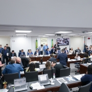 Foto mostra sala de sessões da Comissão de Finanças da Assembleia Legislativa do Estado, com movimentação de pessoas em debate e encaminhamentos durante votação do projeto de lei orçamentária