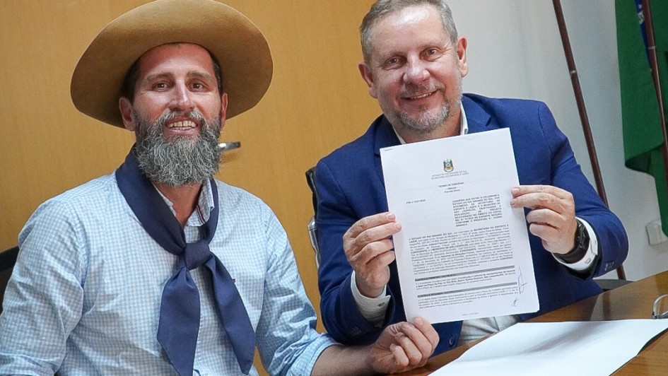 Foto mostra Secretário de Esporte Juliano Franczak e prefeito de São Leopoldo Heliomar Franco apresentando documento assinado em suas mãos