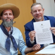 Foto mostra Secretário de Esporte Juliano Franczak e prefeito de São Leopoldo Heliomar Franco apresentando documento assinado em suas mãos